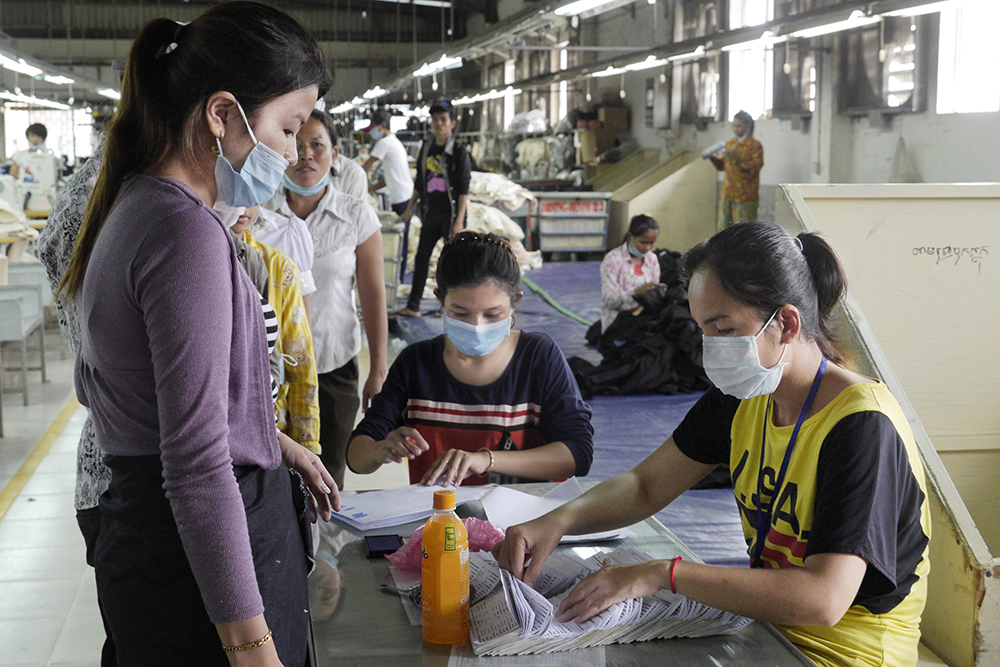 Loonuitbetaling in fabriek Cambodja. Leefbaar loon wereldwijd