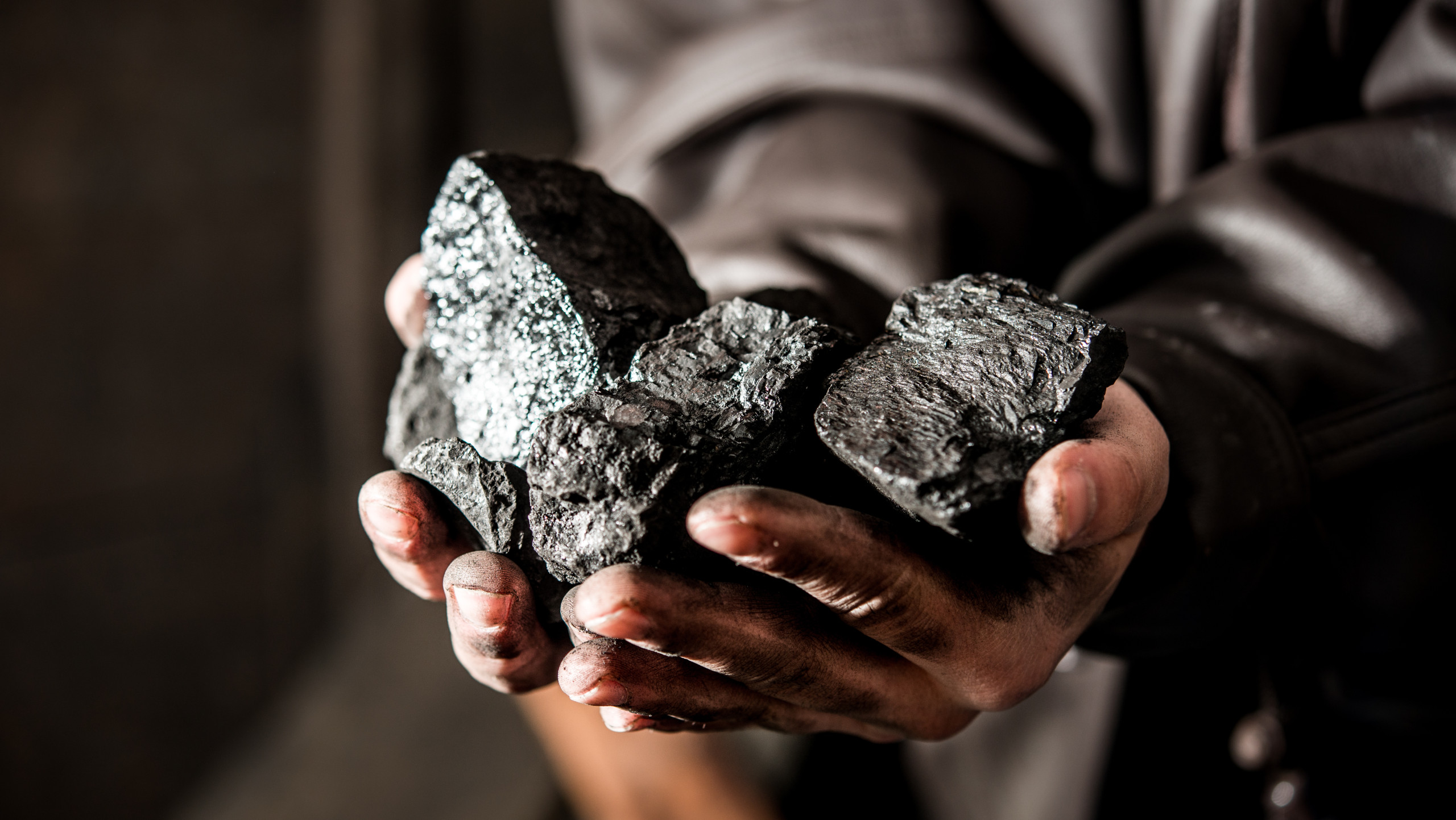 Kolen in handen van mijnwerker. Eerlijke energietransitie mijnbouwsector